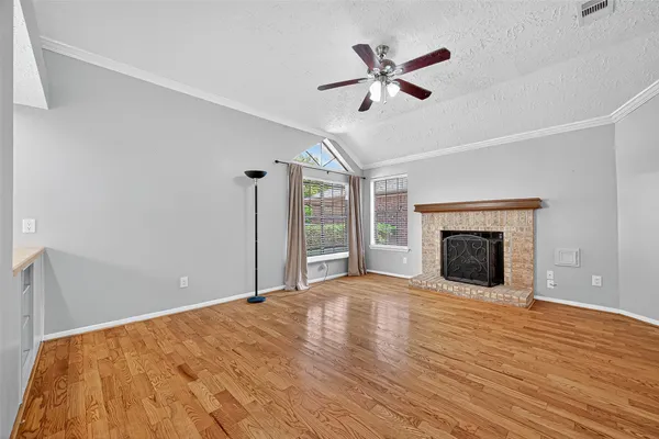 a view of empty room with wooden floor and fireplace