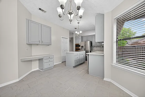 a kitchen with white cabinets and window
