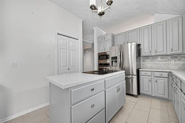 a kitchen with stainless steel appliances white cabinets white stove a refrigerator and a microwave