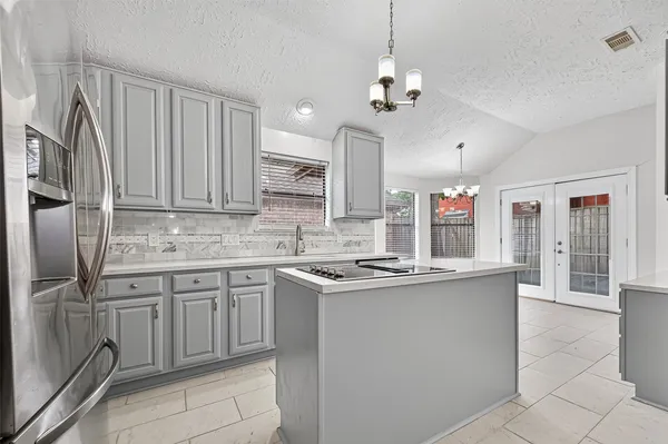 a kitchen with white cabinets and sink