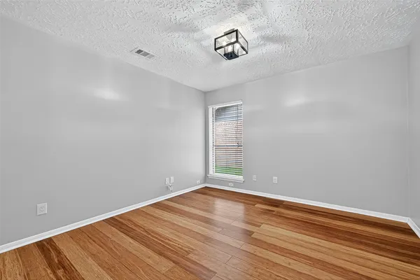 a view of a livingroom with wooden floor and a window