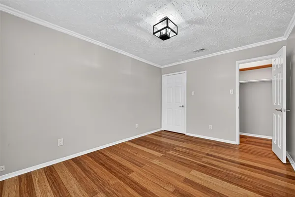 a view of an empty room with a ceiling fan and wooden floor