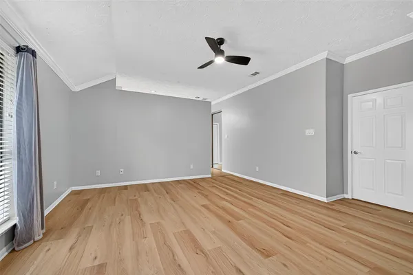 a view of an empty room with wooden floor
