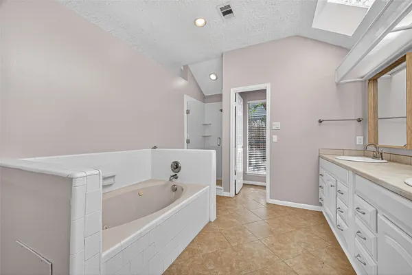 a bathroom with a tub a sink and a large mirror