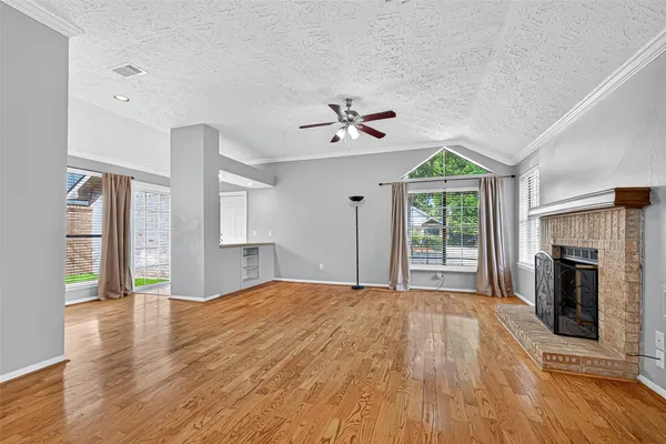 a view of an empty room with a fireplace and a window