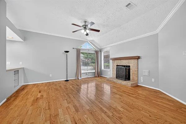 a view of an empty room with window and wooden floor