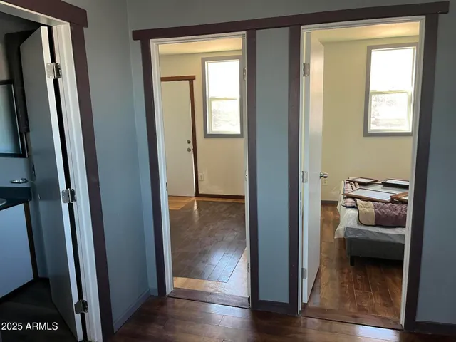 a view of a hallway with wooden floor windows and a livingroom
