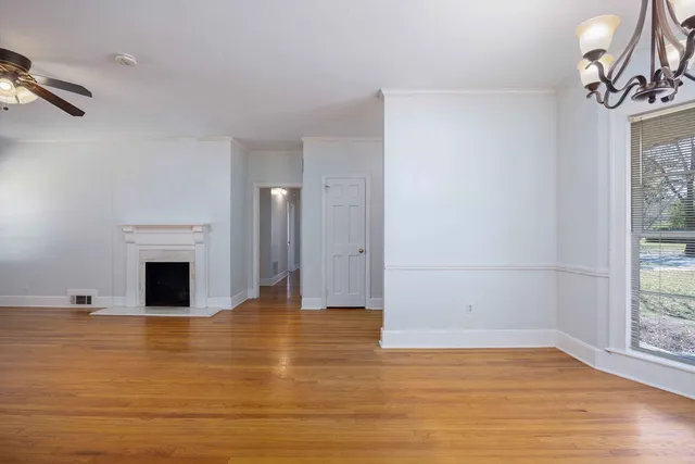 a view of empty room with wooden floor and fireplace