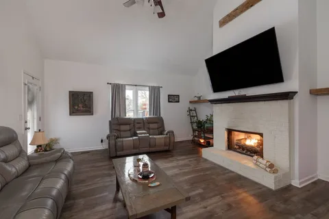 a living room with furniture a flat screen tv and a fireplace