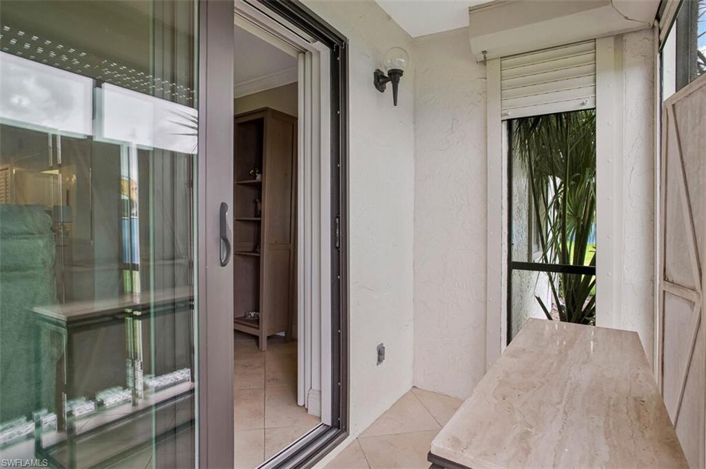 4318 27th Court Southwest, Unit 101 Naples, FL 34116 - Photo 30 of 32 sliding glass door opens to lanai impact resistant slider door and shutters.