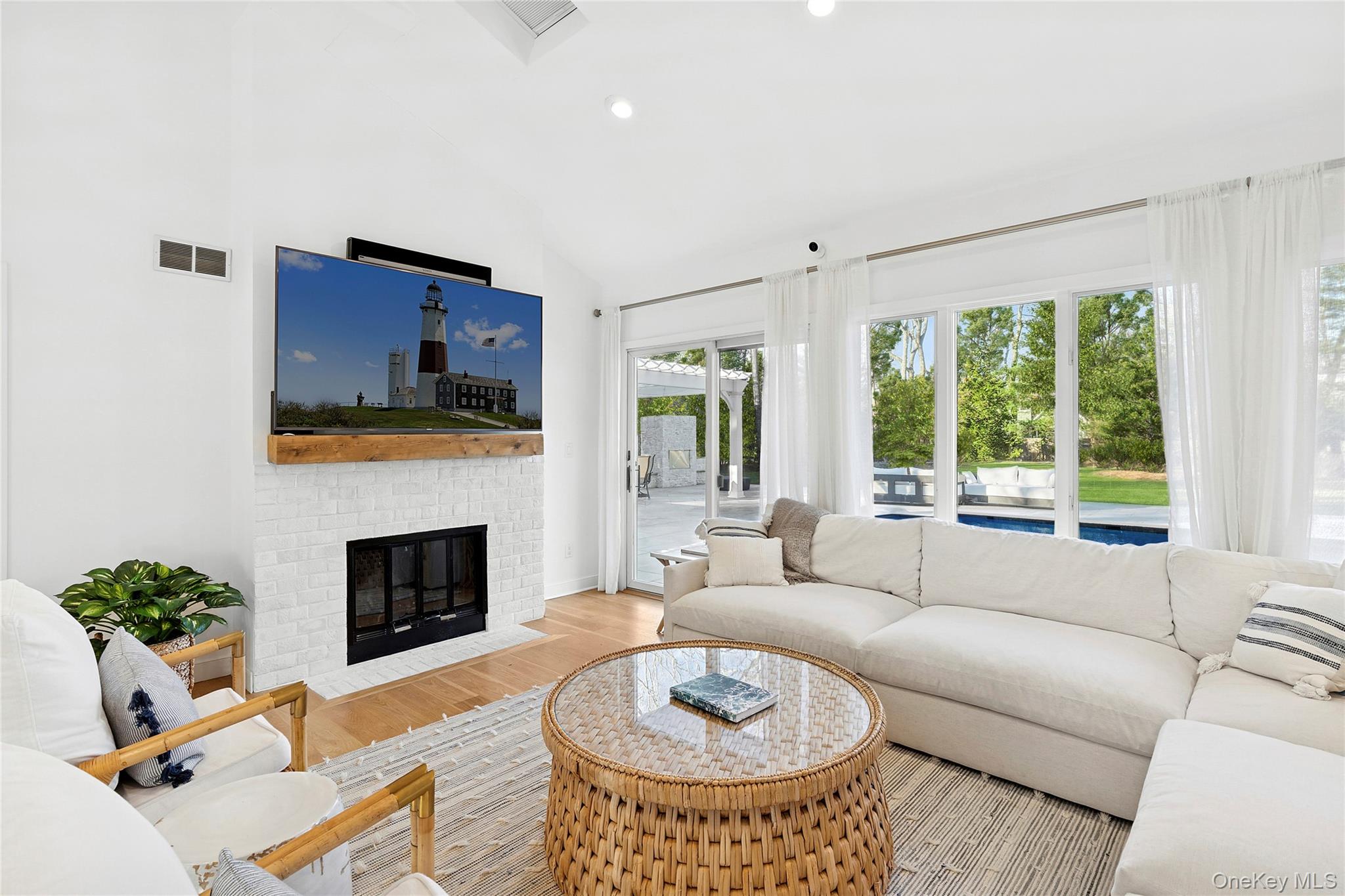 47 Bridle Path Remsenburg, NY 11960 - Photo 3 of 20 a living room with furniture a fireplace and a flat screen tv