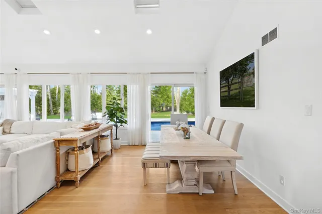 a dining room with a table chairs and a kitchen view