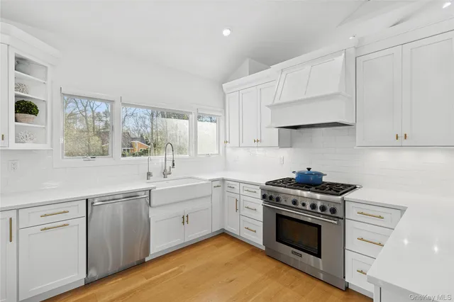 a kitchen with white cabinets and appliances
