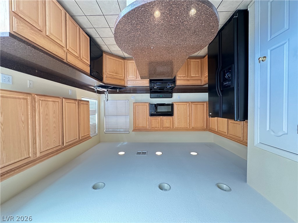9032 Rutherford Grove Street Las Vegas, NV 89148 - Photo 6 of 24 Culinary adventures await in this kitchen featuring abundant wood cabinetry and essential appliances.