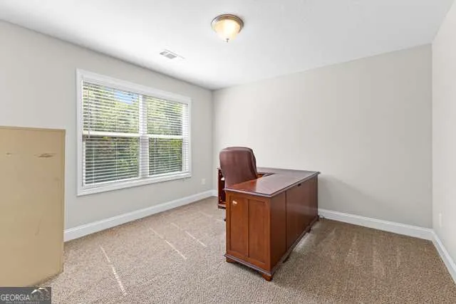 a view of a workspace with furniture and a window