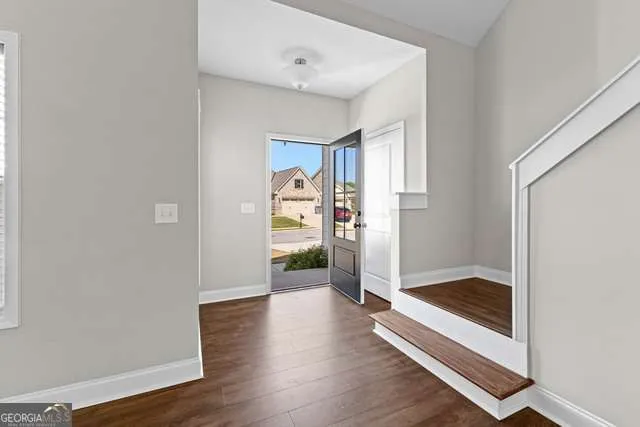 a view of a hallway with wooden floor and cabinet