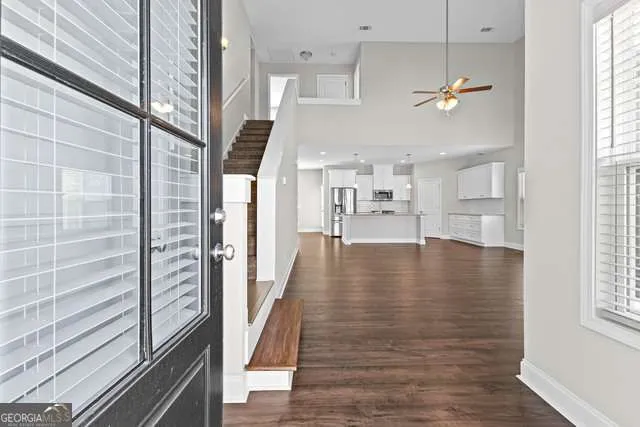 a view of a hallway with wooden floor and staircase