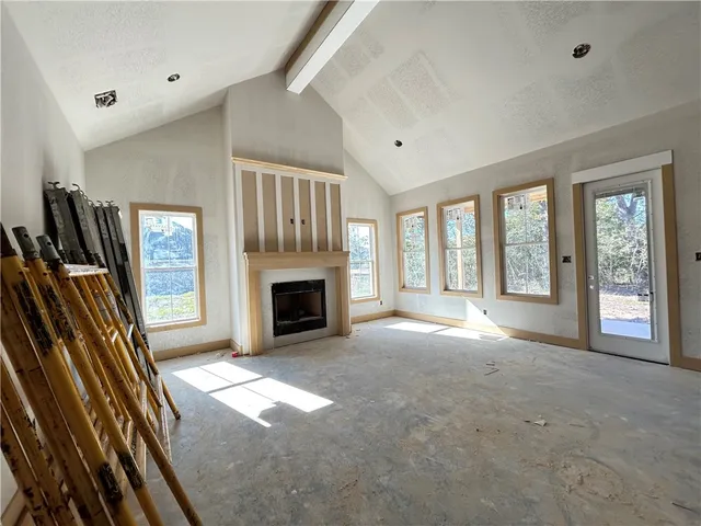 a view of an empty room with a fireplace and a window