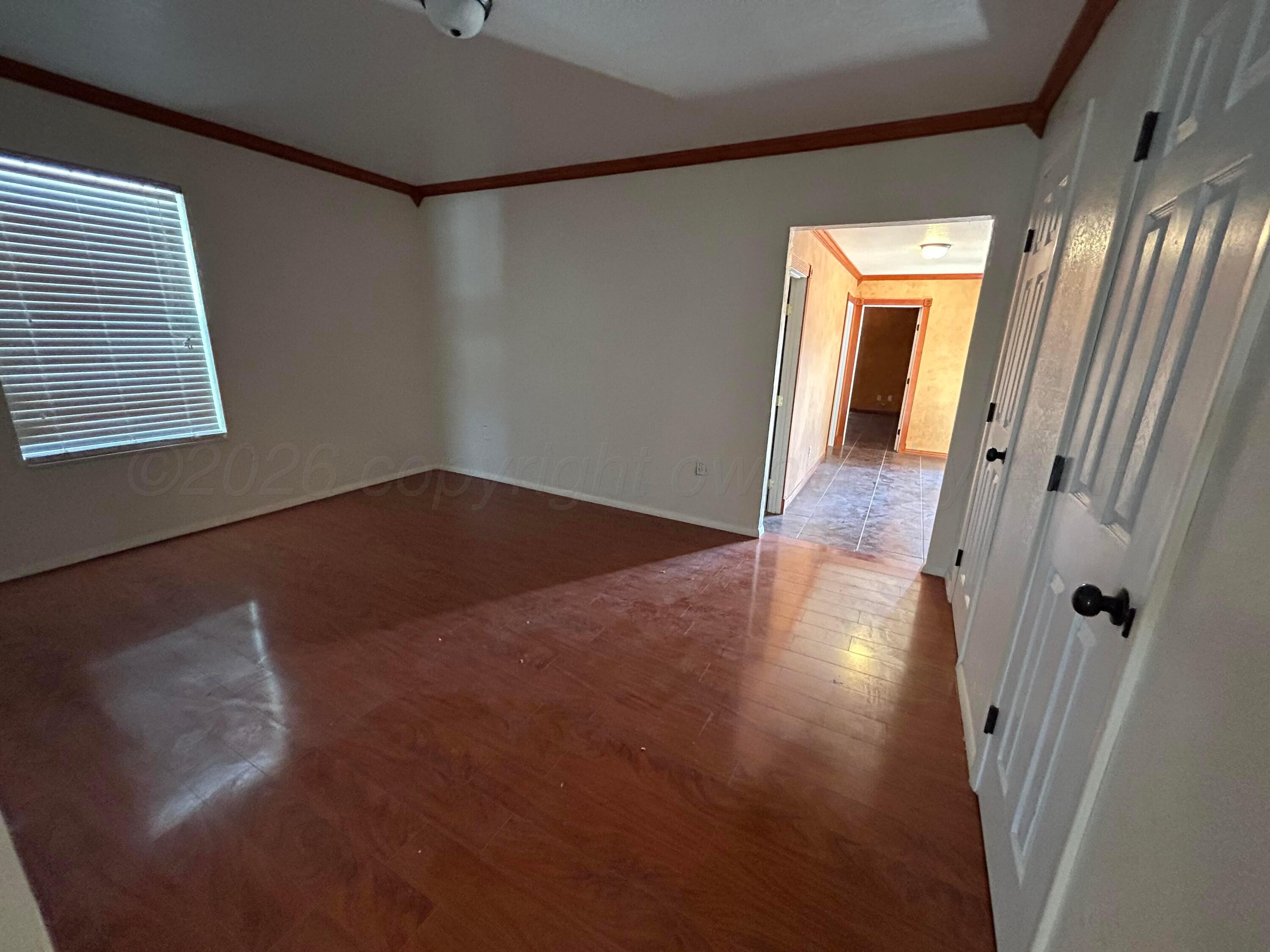 923 Elmore Street Borger, TX 79007 - Photo 12 of 18 an empty room with wooden floor and windows