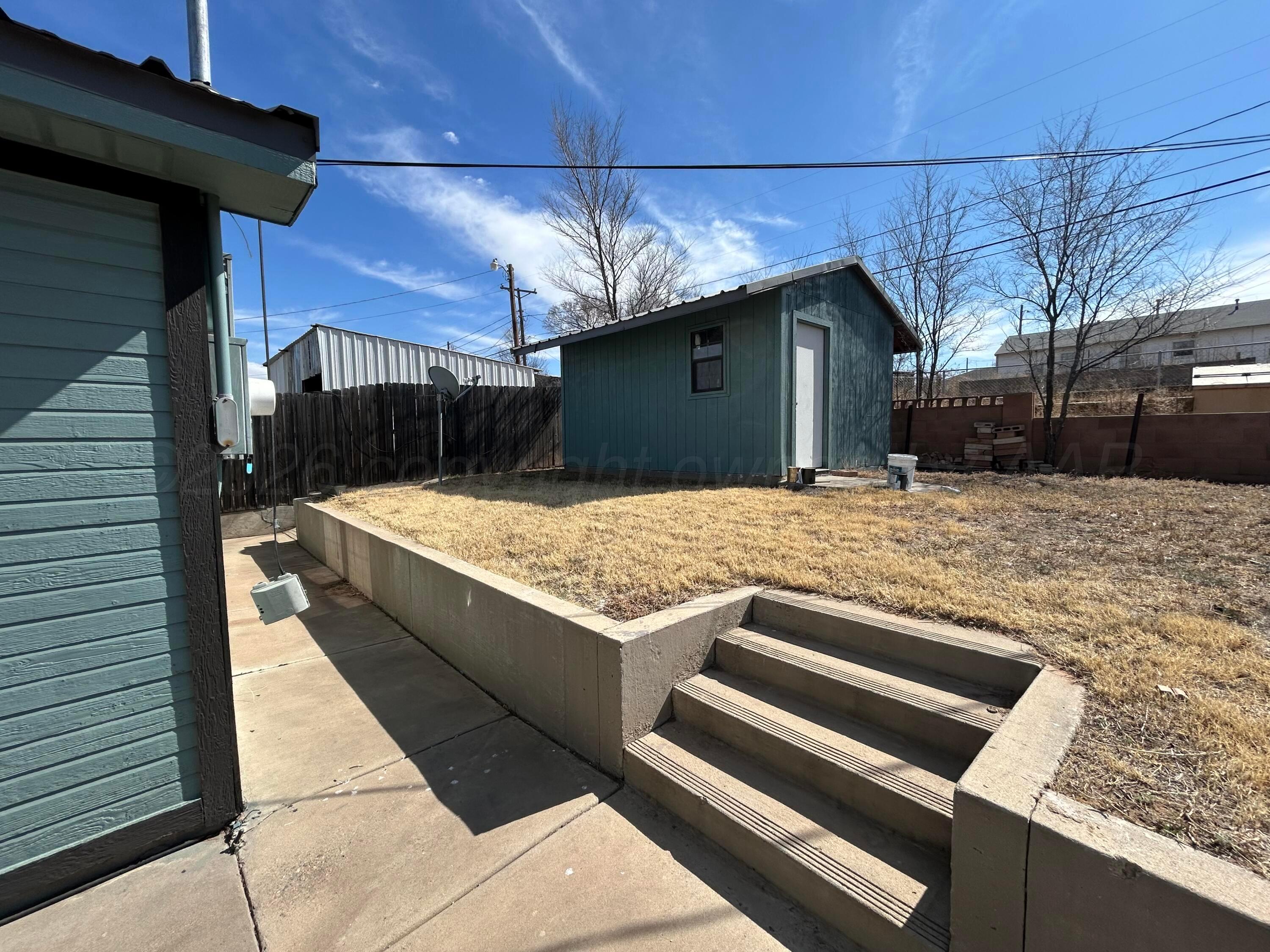 923 Elmore Street Borger, TX 79007 - Photo 17 of 18 a view of a backyard with a fireplace