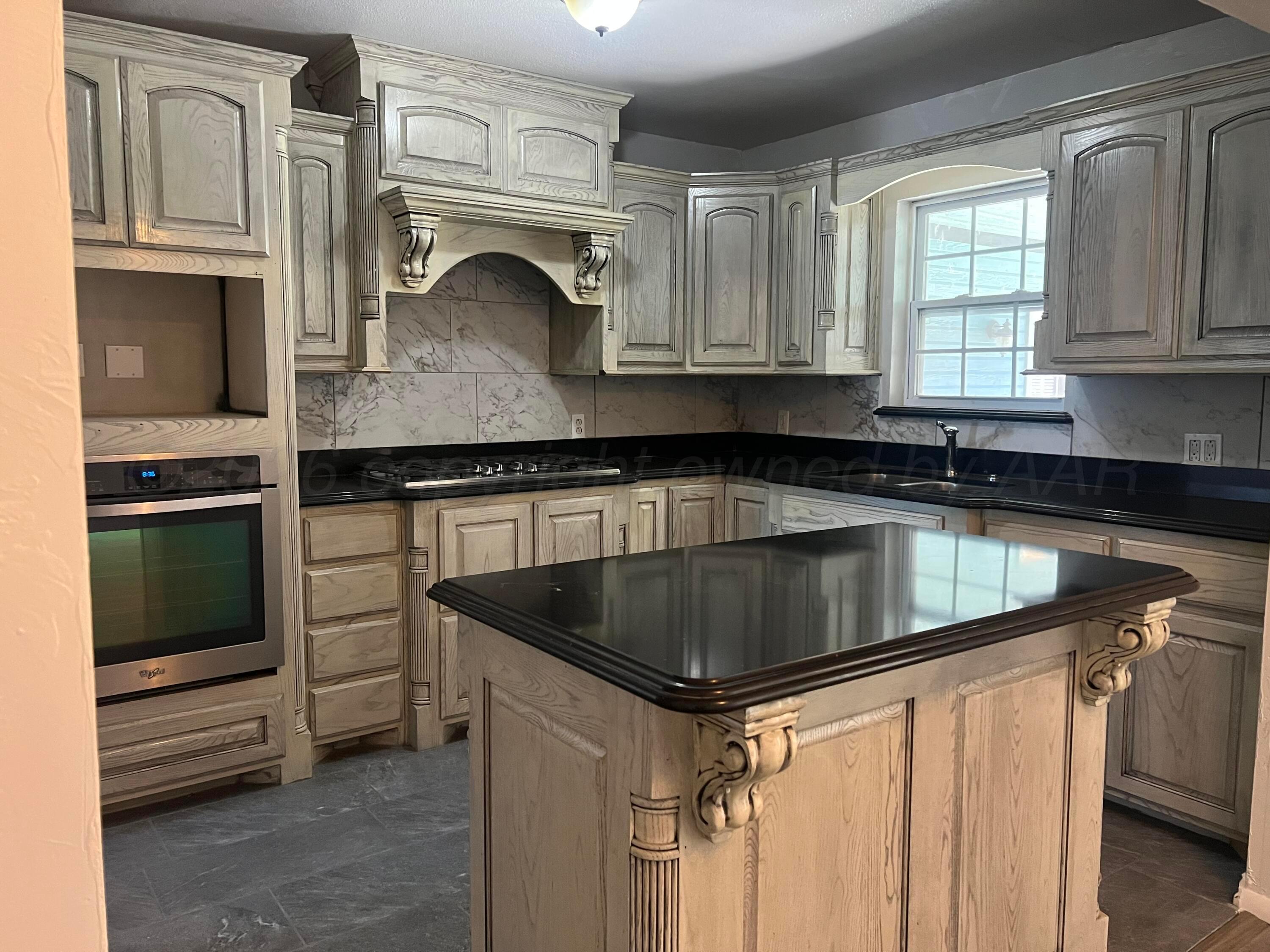 923 Elmore Street Borger, TX 79007 - Photo 3 of 18 a kitchen with granite countertop a sink stove and cabinets