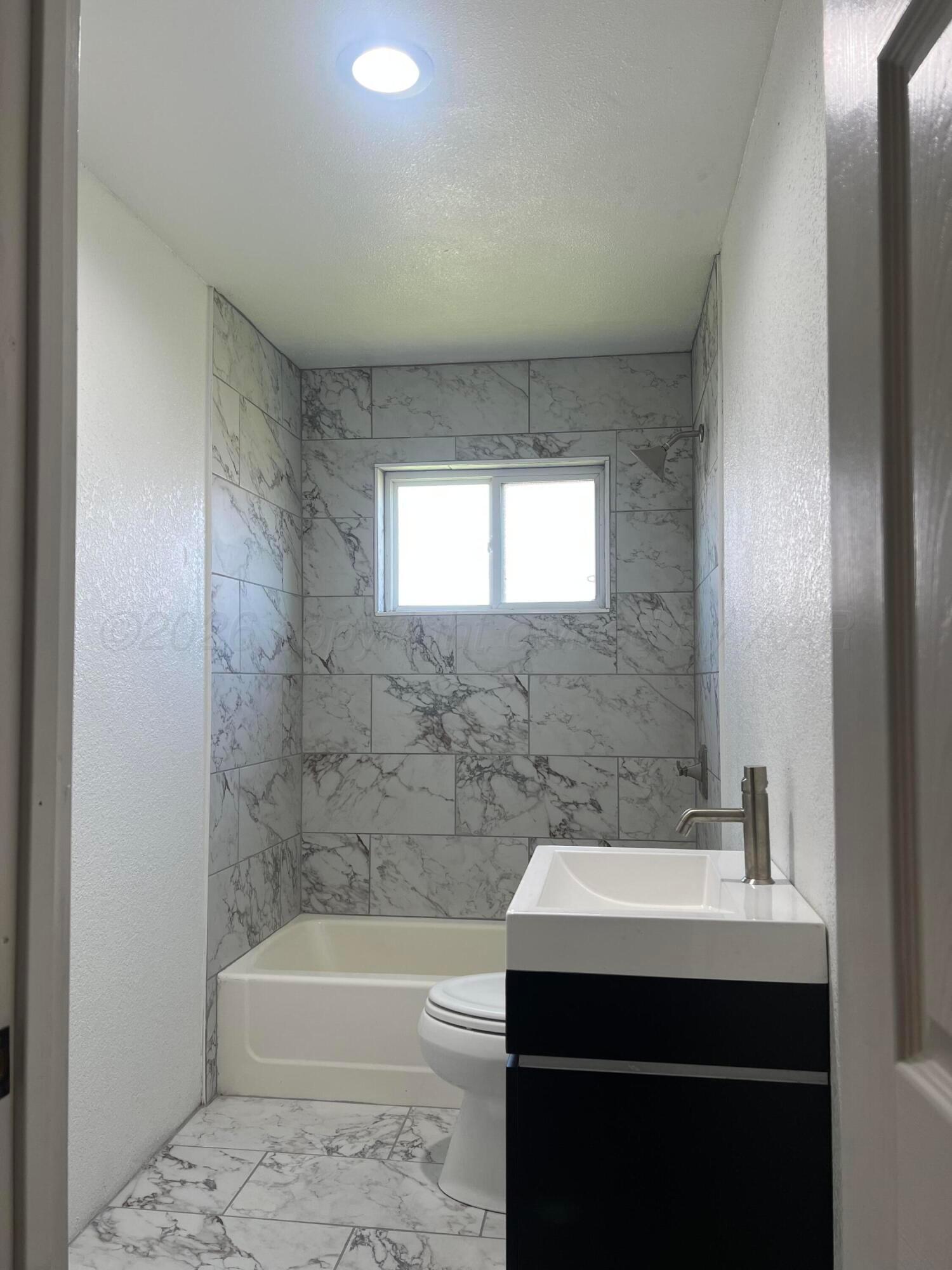 923 Elmore Street Borger, TX 79007 - Photo 4 of 18 a bathroom with a sink a bathtub and a mirror