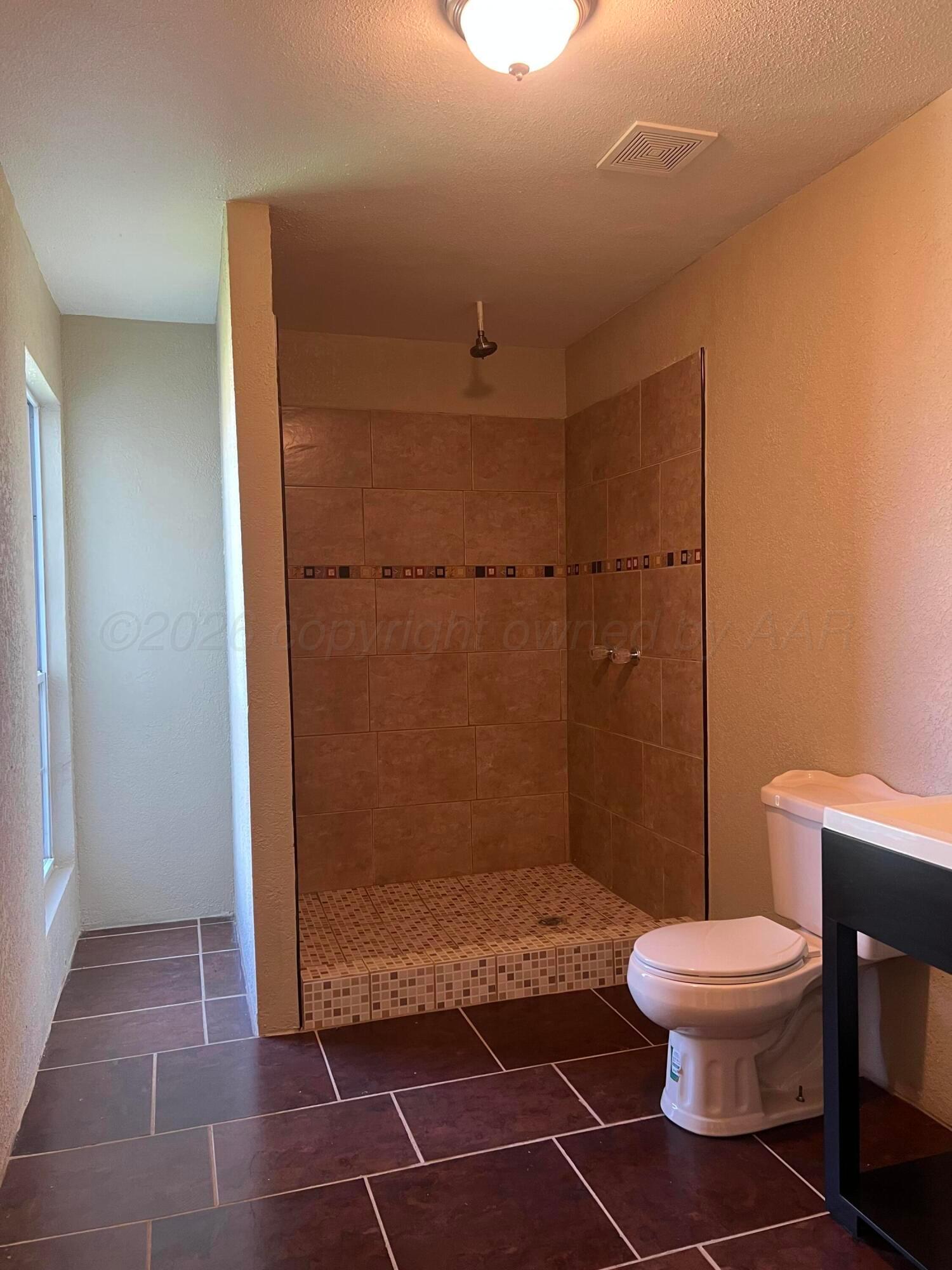 923 Elmore Street Borger, TX 79007 - Photo 5 of 18 a bathroom with a toilet and a shower