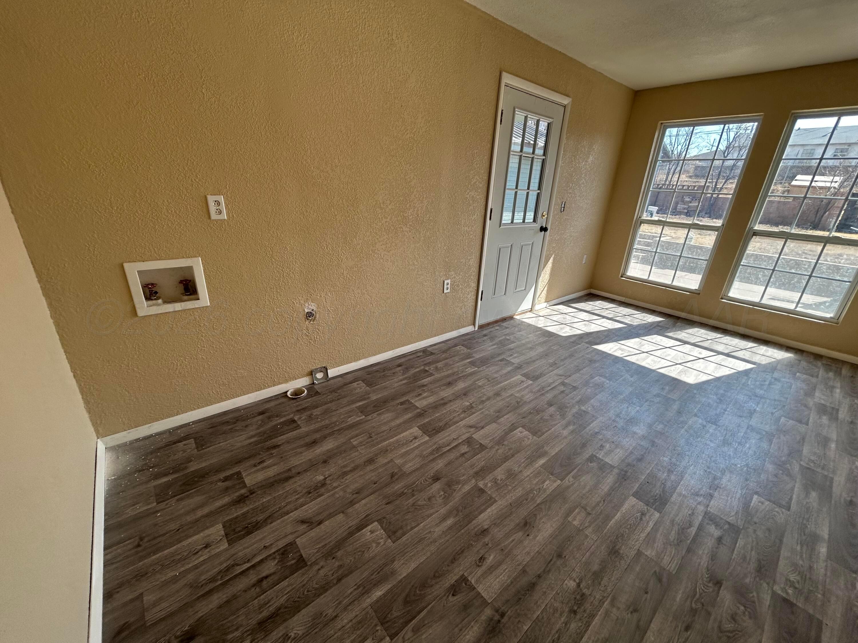 923 Elmore Street Borger, TX 79007 - Photo 8 of 18 a view of an empty room with wooden floor and a window