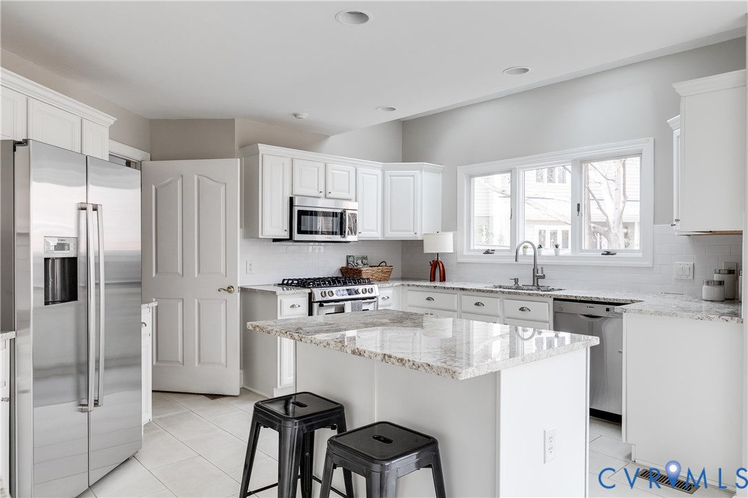 3207 Stony Point Road, Unit C Richmond, VA 23235 - Photo 16 of 40 a kitchen with kitchen island a refrigerator stove microwave and cabinets