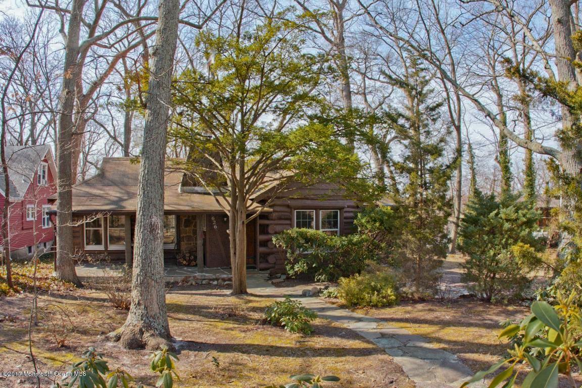 a front view of a house with a yard and large trees