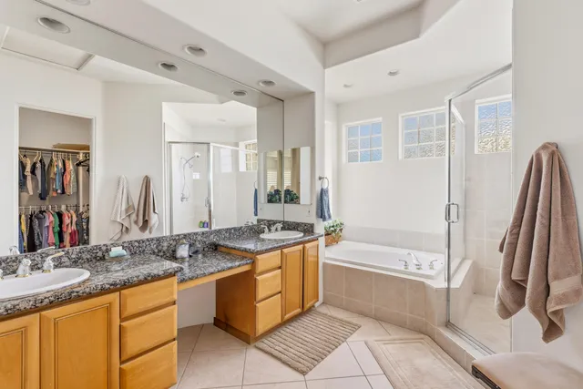 a bathroom with a granite countertop tub sink and a mirror