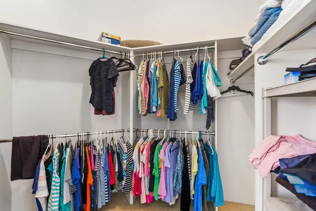 a view of walk in closet with clothes