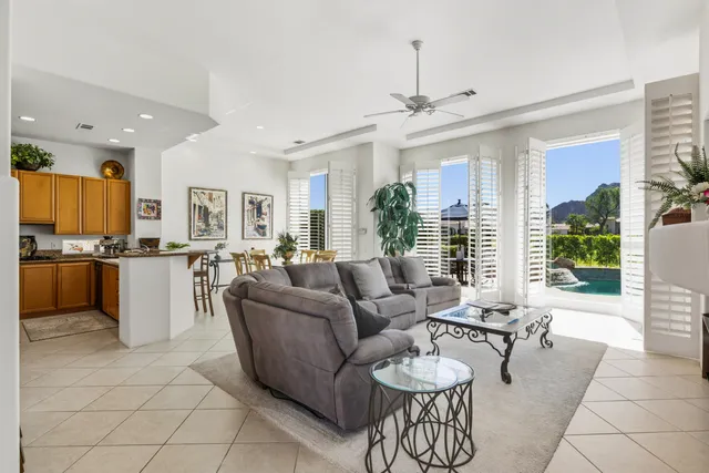 a living room with couches a dining table and chairs with kitchen view