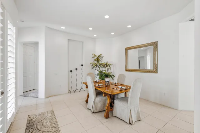 a dining room with furniture and a potted plant