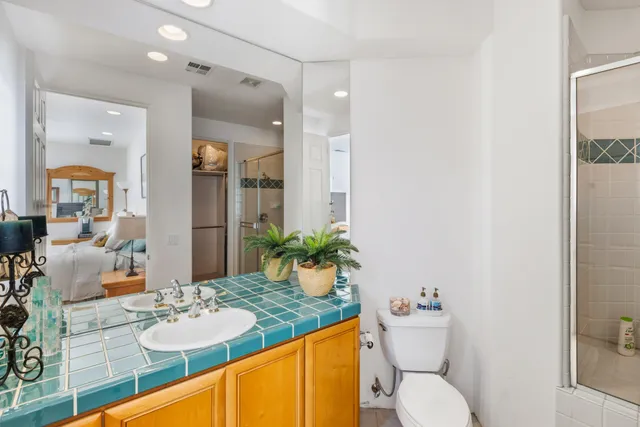 a bathroom with a granite countertop sink mirror vanity and toilet