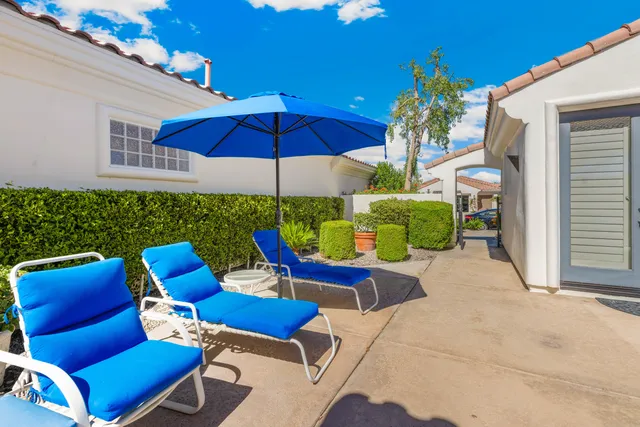 a view of a patio with a table and chairs under an umbrella