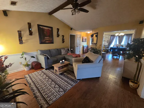 a living room with furniture and wooden floor