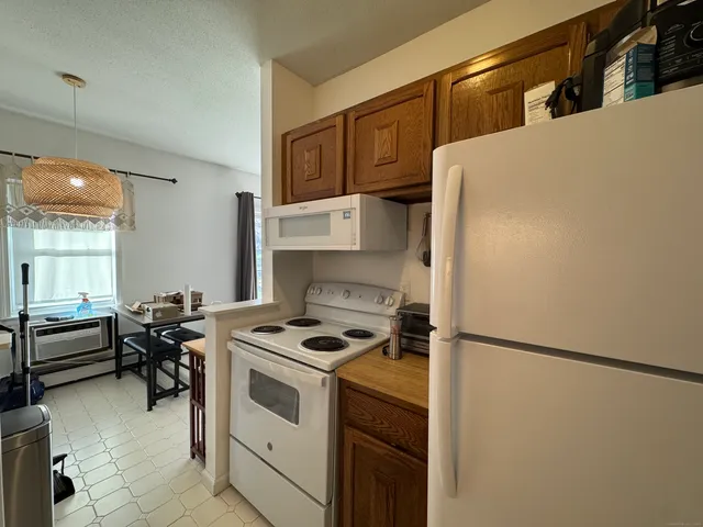 a kitchen with a refrigerator and a stove top oven