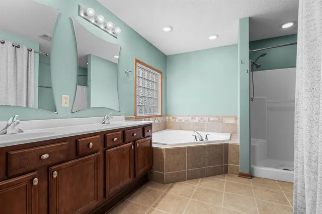 a spacious bathroom with a bathtub shower sink and mirror