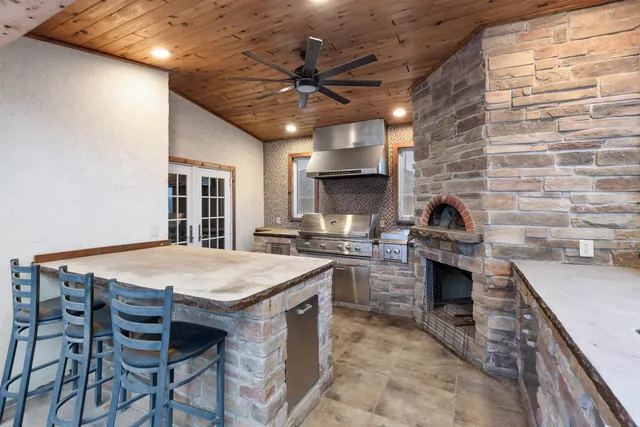 a kitchen with a stove a sink a dining table and chairs with wooden floor