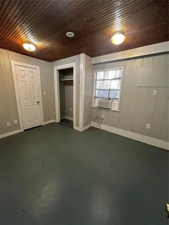 an empty room with a wooden space and window