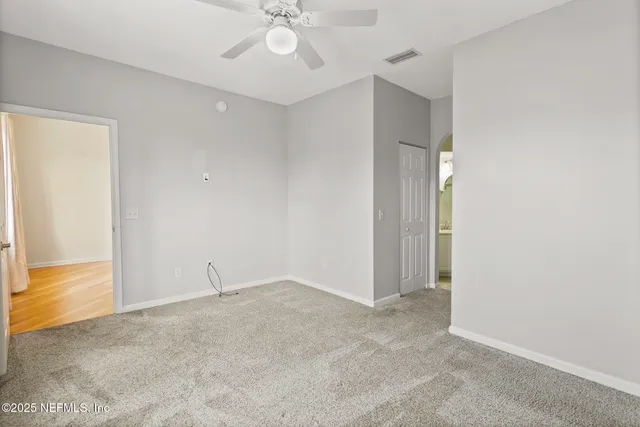 a view of a hallway with closet and mirror