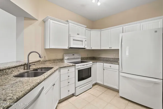 a kitchen with white cabinets sink and white appliances