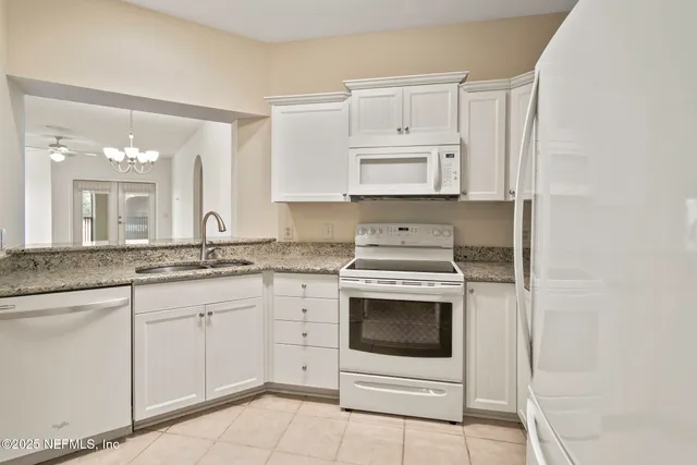 a kitchen with white cabinets stainless steel appliances and sink