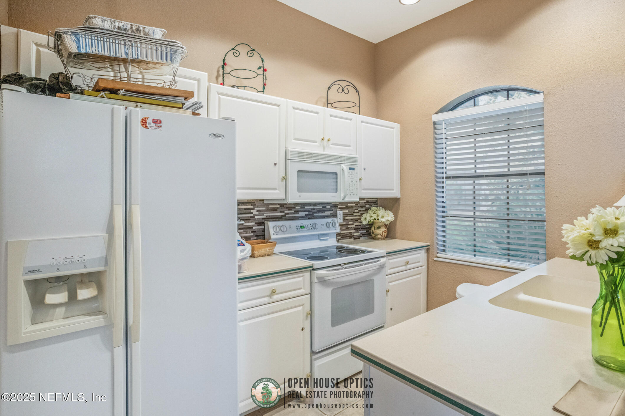 2521 Vista Cove Road St. Augustine, FL 32084 - Photo 57 of 64 a kitchen with a sink dishwasher stove and white cabinets