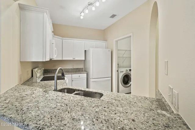 a kitchen with a stove a refrigerator and cabinets