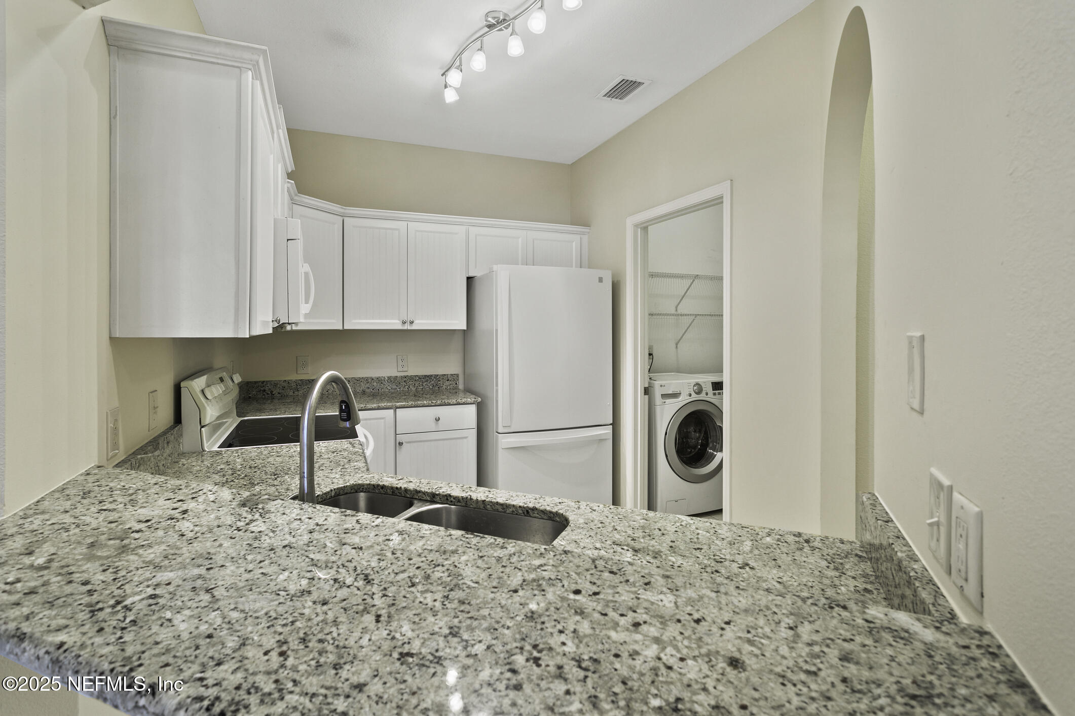 2521 Vista Cove Road St. Augustine, FL 32084 - Photo 6 of 64 a kitchen with a stove a refrigerator and cabinets