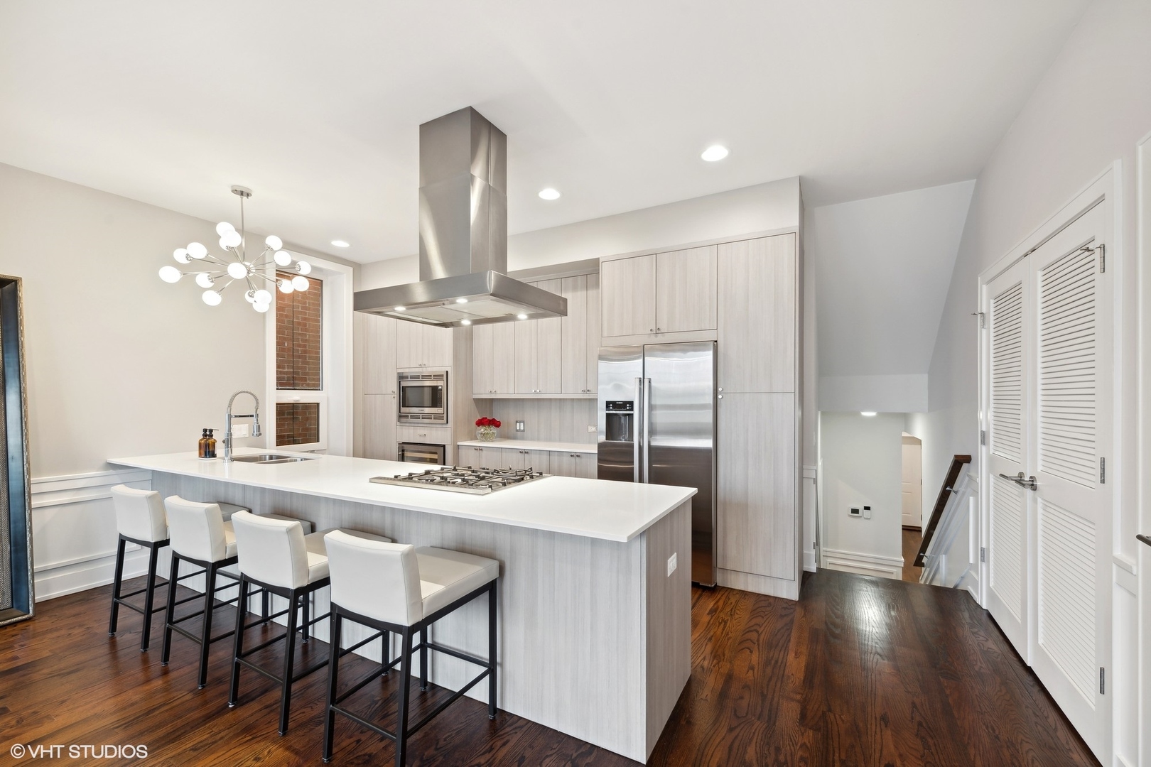 3003 North California Avenue, Unit 2N Chicago, IL 60618 - Photo 6 of 17 a kitchen with stainless steel appliances kitchen island granite countertop a kitchen island hardwood floor and a sink