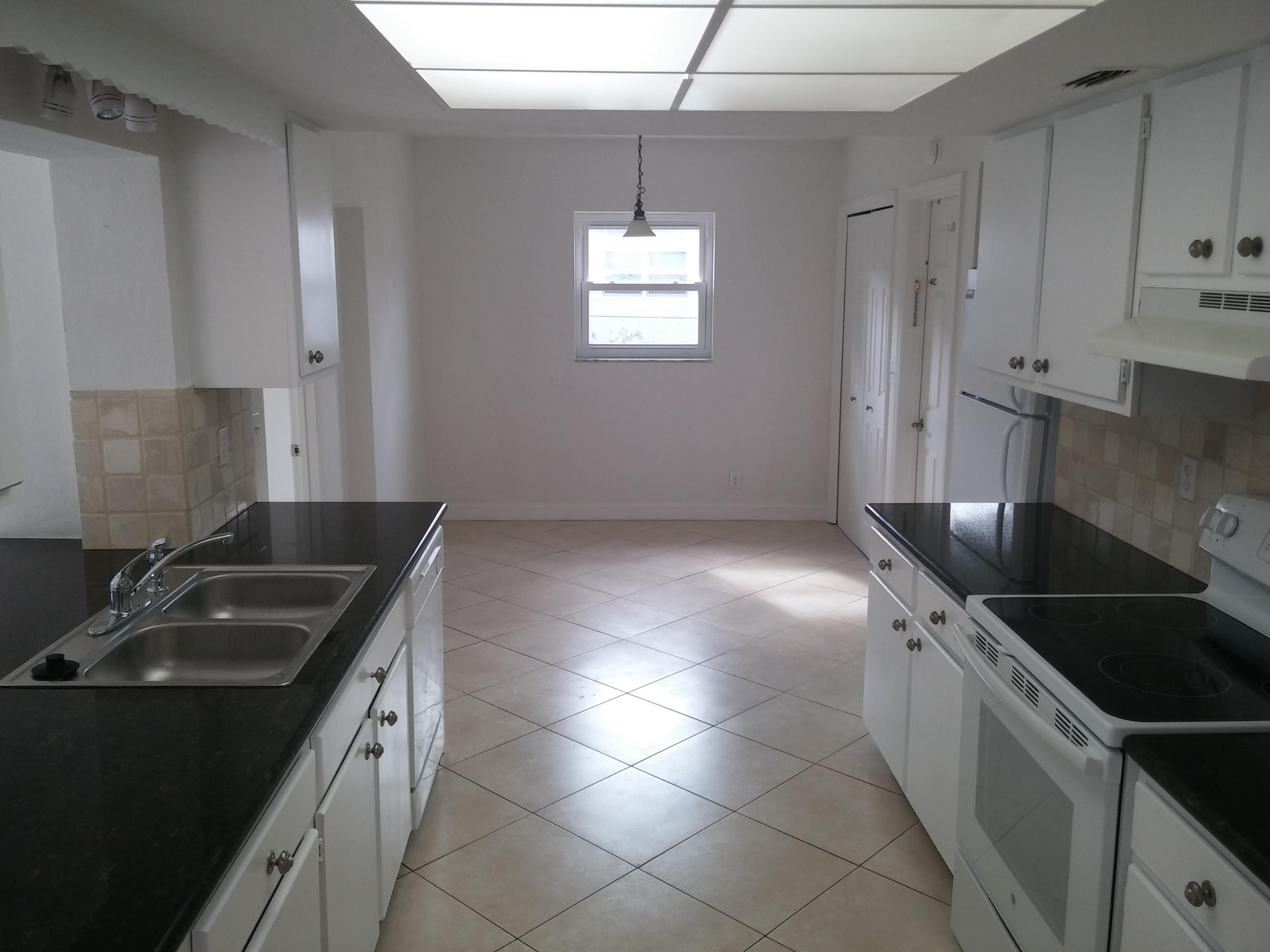 29 Tam O Shanter Lane Boca Raton, FL 33431 - Photo 4 of 18 a kitchen that has a sink and a stove