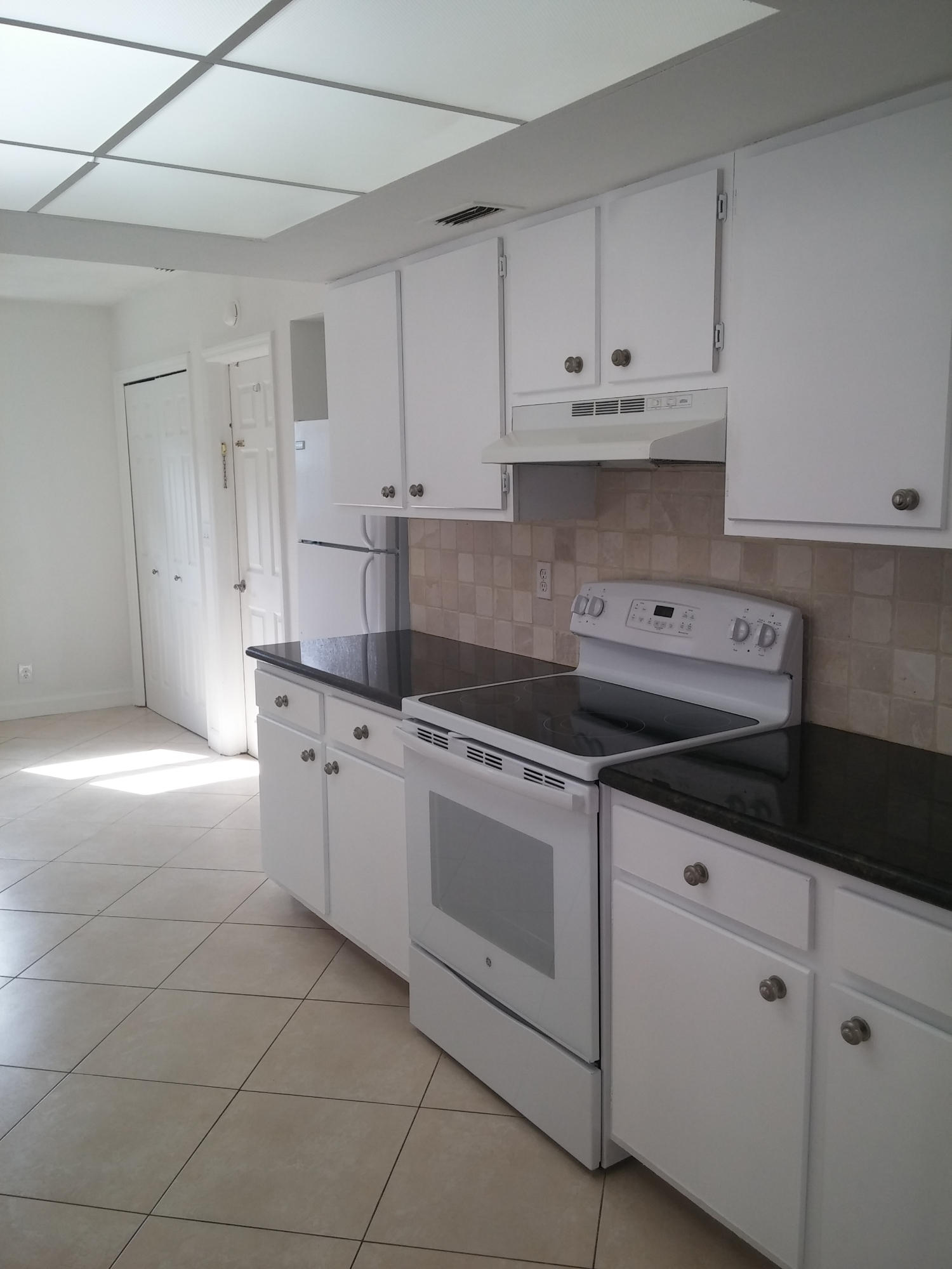 29 Tam O Shanter Lane Boca Raton, FL 33431 - Photo 6 of 18 a kitchen with granite countertop white cabinets and white appliances